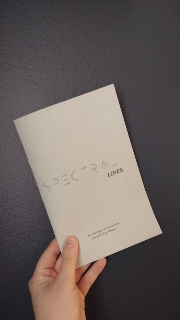 A hand holding a copy of Spectral Lines