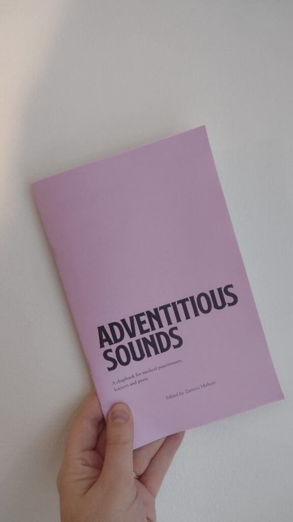 A hand holding a copy of Adventitious Sounds