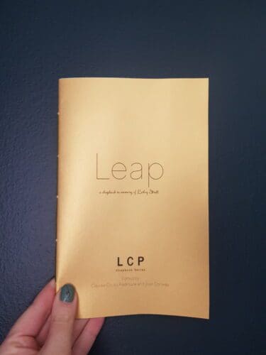 A hand holding a copy of Leap