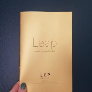 A hand holding a copy of Leap