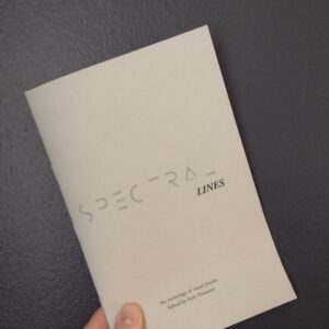 A hand holding a copy of Spectral Lines